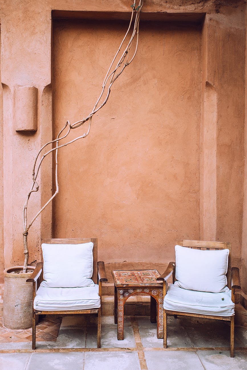 aged armchairs near small table in patio